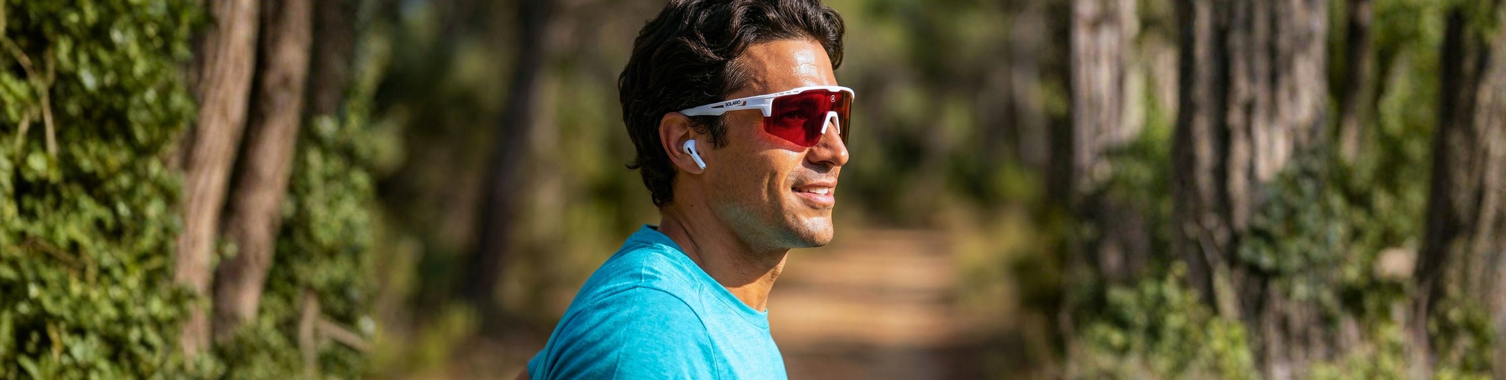 Man wearing a blue athletic shirt and reflective Solaro Shades running sunglasses outdoors