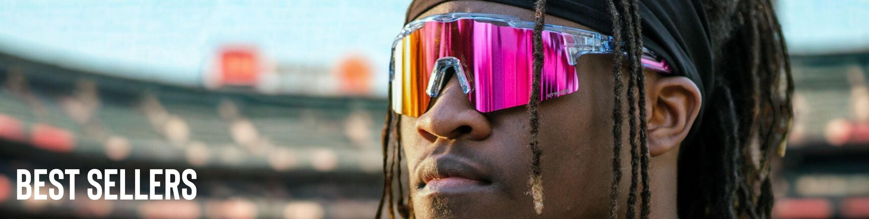 Person wearing colorful reflective Solaro Shades baseball sunglasses with a blurred stadium background