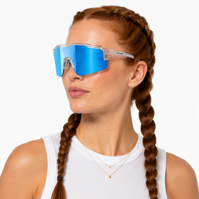 Woman wearing blue solaro shades mirrored sports sunglasses with a white background.