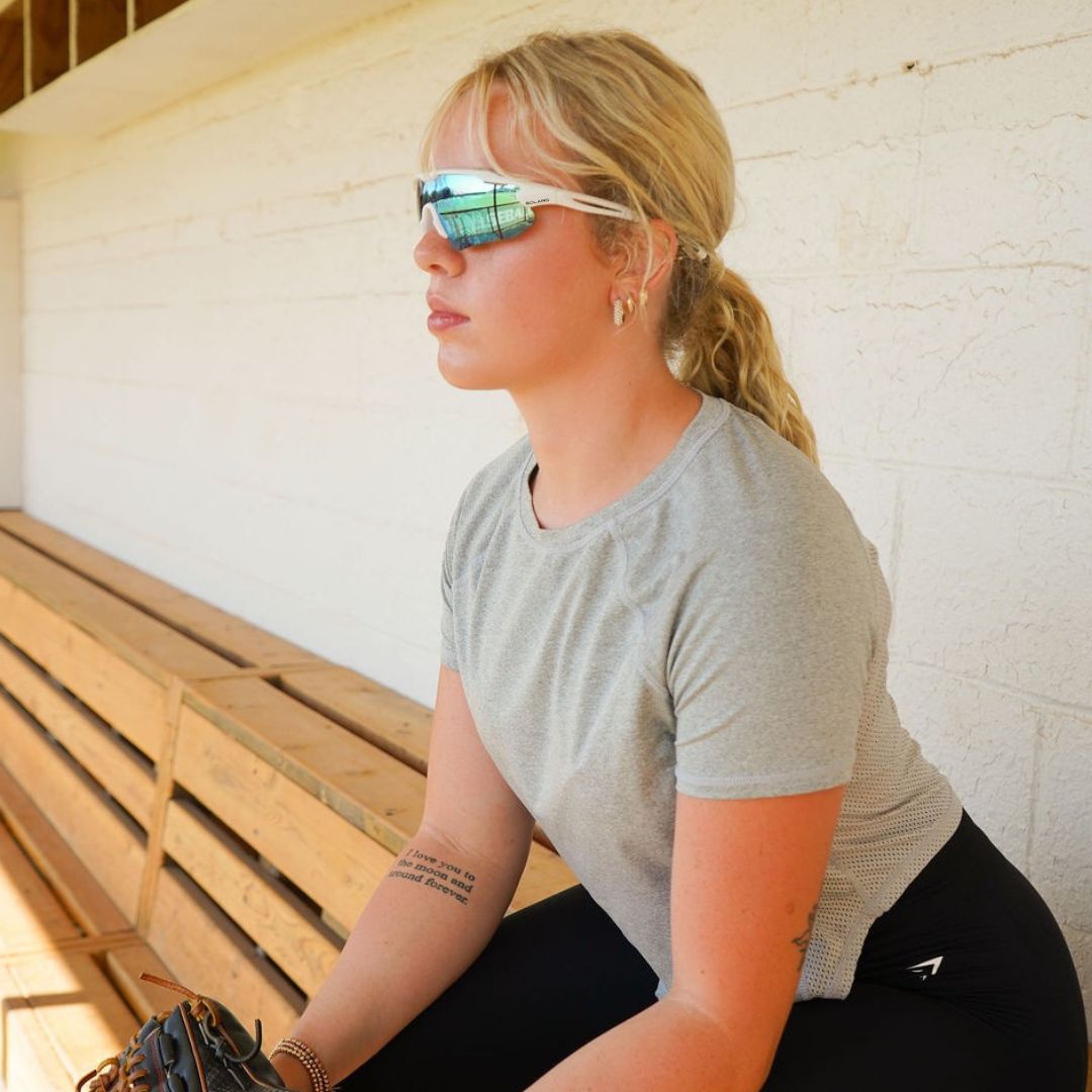Solaro Shades Nova Sunglasses for Softball, baseball, pickleball, and running. Best sports sunglasses for women and men.  White frame and blue lenses. Graci Major is the model.