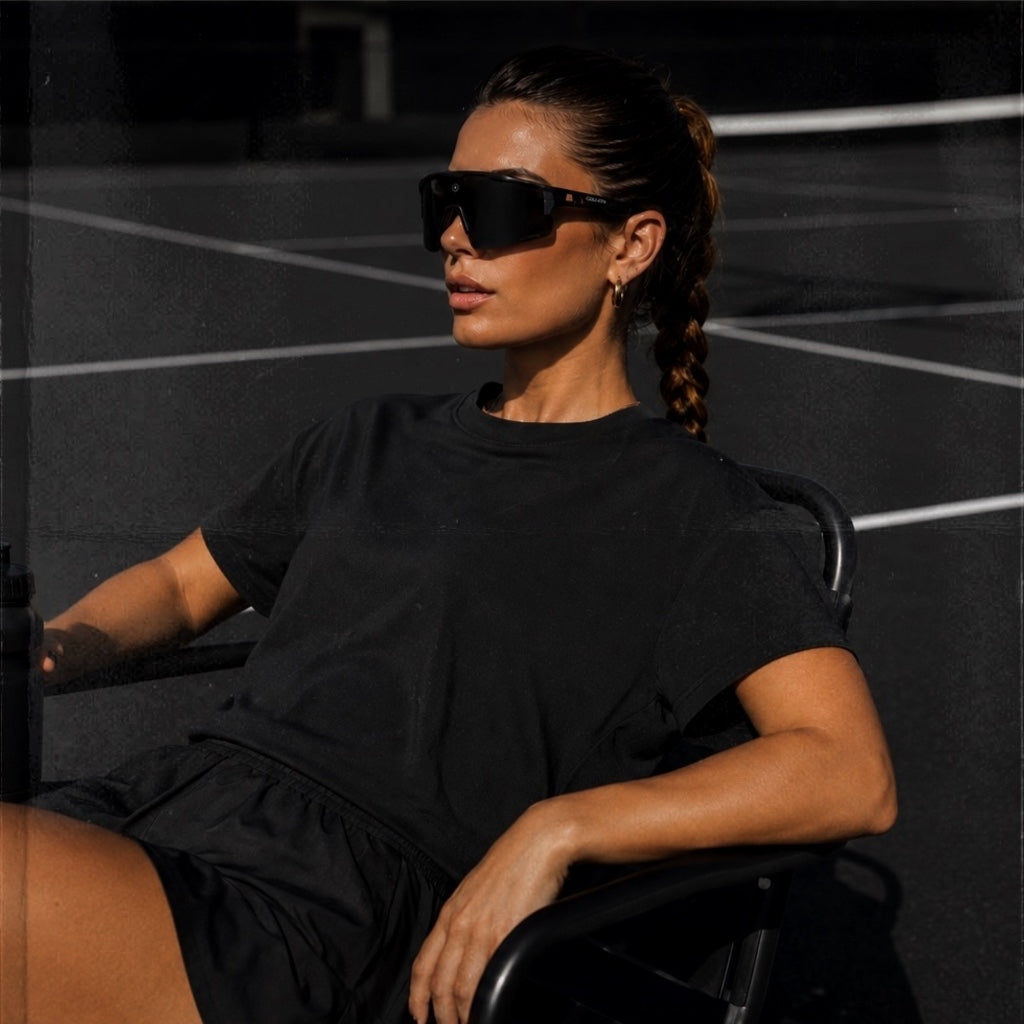 Female athlete wearing Blackout Cosmo baseball sunglasses by Solaro Shades while playing sports.