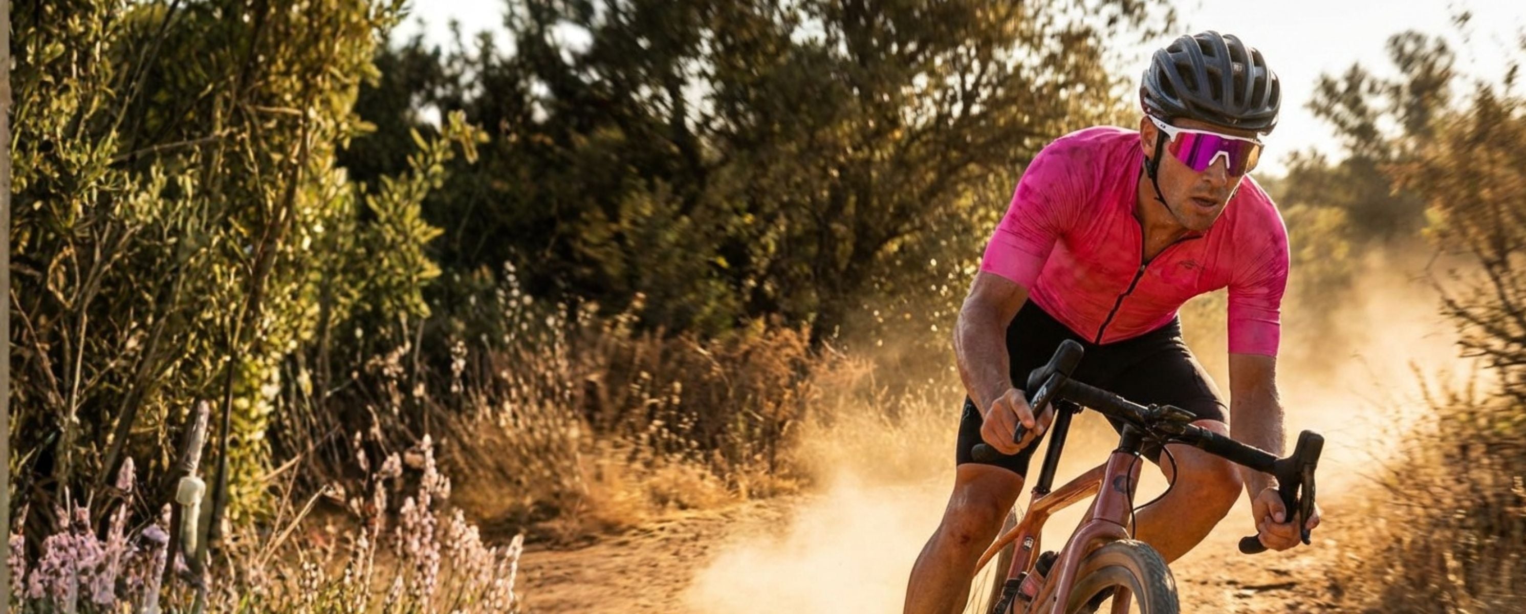 Person riding a bicycle on a dirt path with a pink jersey and helmet and Solaro Shades cycling sunglasses