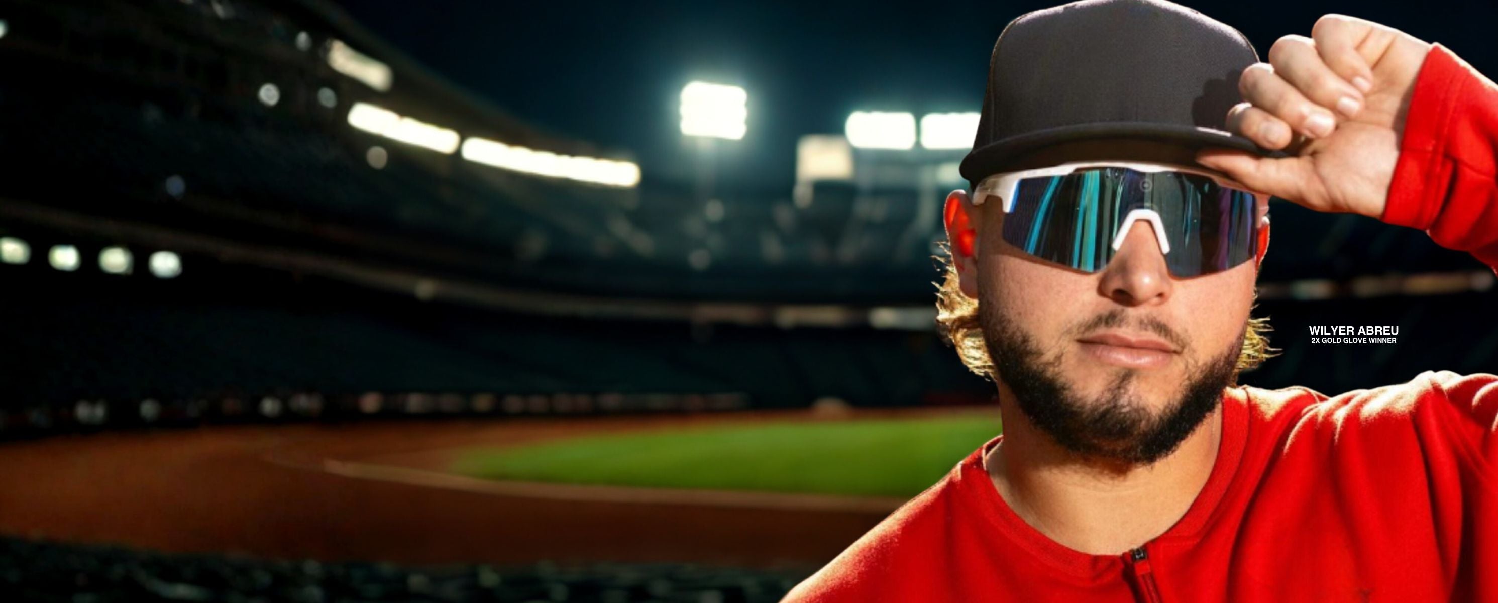 Wilyer Abreu wearing baseball sunglasses from Solaro Shades with a baseball red shirt and sunglasses with a baseball cap, standing on a baseball field.