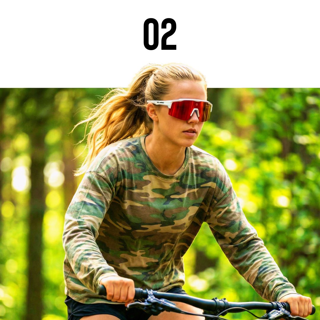 Woman riding a bike in a forest wearing camouflage clothing and red solaro shades sports sunglasses for biking sunglasses.