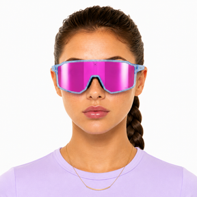 Person wearing reflective blue and pink solaro pluto style sunglasses with a plain background