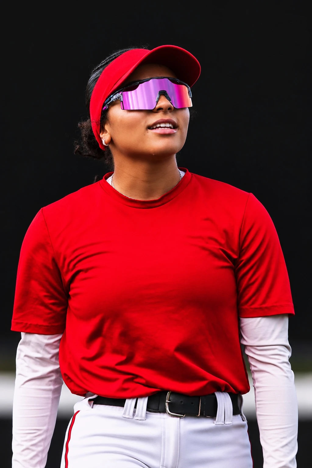 Softball athlete in a red visor and jersey wearing mirrored Solaro sunglasses